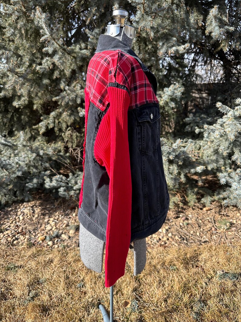 Puede incluir: Chaqueta vaquera con canes&uacute; a cuadros rojos y negros y mangas de punto acanalado rojo. La chaqueta tiene cuello negro y cierre de botones. La chaqueta se exhibe en un maniqu&iacute; al aire libre.