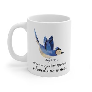 May include: White ceramic mug with a blue jay illustration and the text "When a blue jay appears a loved one is near".