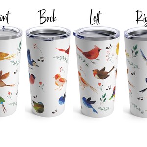 May include: A white tumbler with a colorful bird pattern. The tumbler has a lid and is made of stainless steel. The birds are depicted in a watercolor style and include bluebirds, cardinals, and yellow birds. The tumbler is perfect for holding hot or cold beverages.