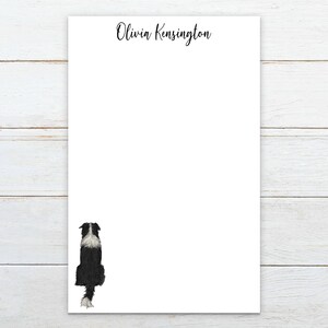 May include: White stationery with the name "Olivia Kensington" in black script at the top. A black and white dog illustration is at the bottom left. The stationery is on a white wooden surface.