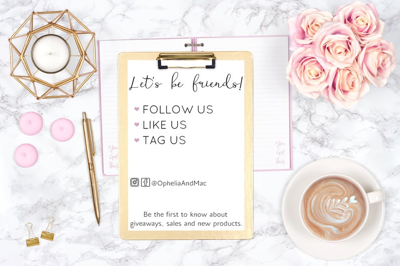 May include: A flat lay featuring a gold clipboard with the text "Let's be friends!" and social media prompts. Accompanying items include a gold pen, candle holder, pink candles, and a cup of coffee with latte art, all on a marble surface.