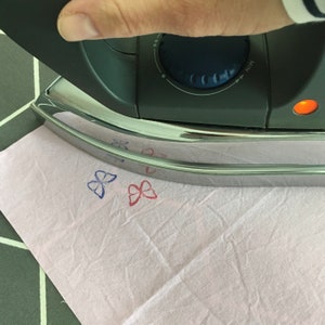 Motiv von links Bügeln um es zu fixieren auf dem Stoff. Hier haben wir kleine Schmetterlinge gestempelt.