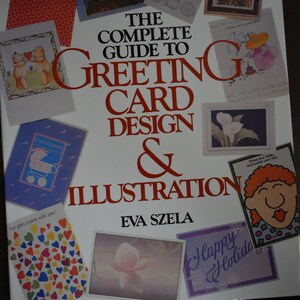 May include: A book titled "The Complete Guide to Greeting Card Design & Illustration" by Eva Szela. The cover features various greeting card designs, including illustrations of bears, a baby carriage, and flowers. The book's title is in large red letters.