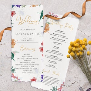 May include: Wedding ceremony program with floral illustrations. The program includes the order of events, officiant, wedding party, and special thanks. The text is in gold lettering on a white background.