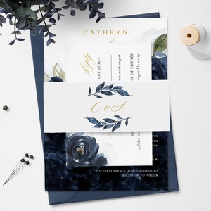 May include: A wedding invitation suite with a navy blue and white floral design. The invitation features the names "Cathryn" and "CoS" in gold lettering. The RSVP card includes the date "30th of May" and the text "nes with regret". The menu card includes the text "CE OF ENTR&Eacute;E" and "vegetable curry".