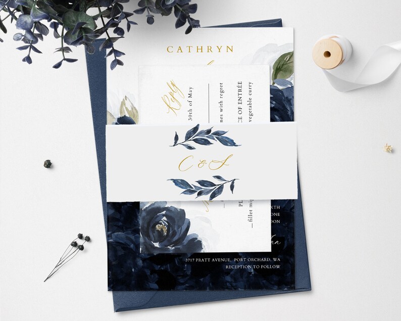 May include: A wedding invitation suite with a navy blue and white floral design. The invitation features the names "Cathryn" and "CoS" in gold lettering. The RSVP card includes the date "30th of May" and the text "nes with regret". The menu card includes the text "CE OF ENTR&Eacute;E" and "vegetable curry".