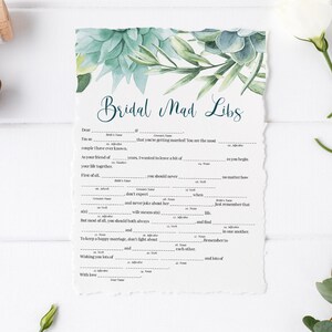 May include: A printable bridal mad libs game with a watercolor background of green succulents and leaves. The text reads "Bridal Mad Libs".