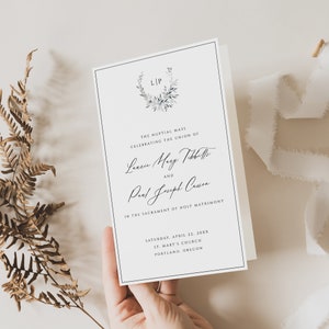 Puede incluir: Invitación de boda con fondo blanco y texto negro. La invitación anuncia la misa nupcial que celebra la unión de Laurie Mary Tibbetts y Paul Joseph Casson. La ceremonia tendrá lugar el sábado 22 de abril de 20XX en la iglesia de St. Mary's en Portland, Oregón.