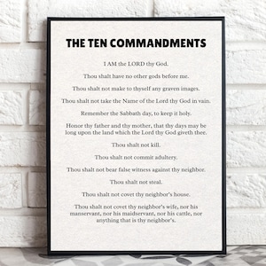 May include: A framed print featuring "THE TEN COMMANDMENTS" in bold black text at the top. The text of the commandments is centered on a light background. The frame is black, and the print is displayed against a textured wall.