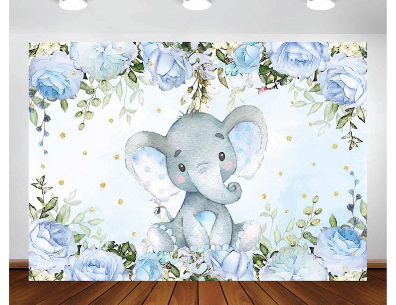 Op de afbeelding: Een aquarel-illustratie van een babyblauwe olifant met blauwe en witte stippen, omringd door blauwe bloemen en groen op een lichtblauwe achtergrond met gouden glitter.