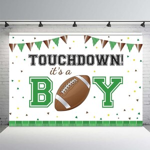 May include: A white and green football-themed baby shower backdrop with the text "TOUCHDOWN! it's a BOY" and a brown football in the center.