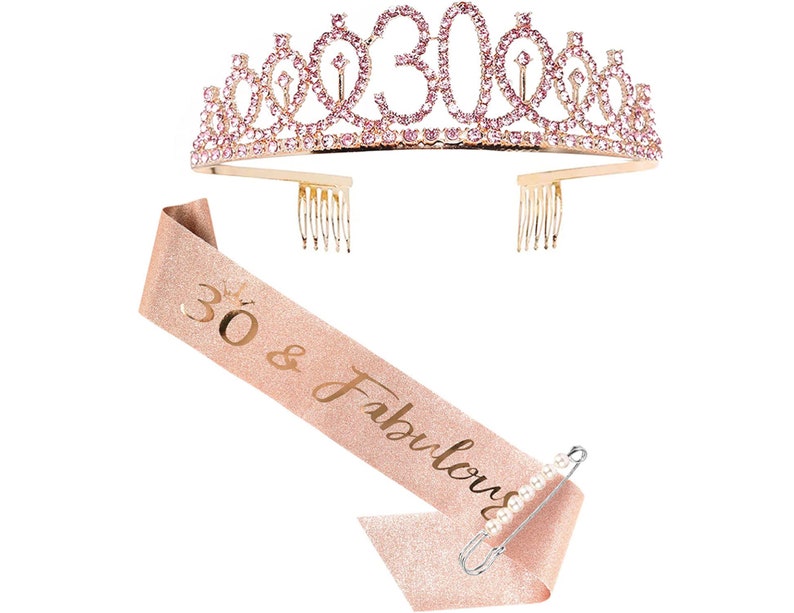 May include: A gold tiara with pink rhinestones and the number 30 on top. A pink and gold sash with the text "30 & Fabulous" and a safety pin are included.
