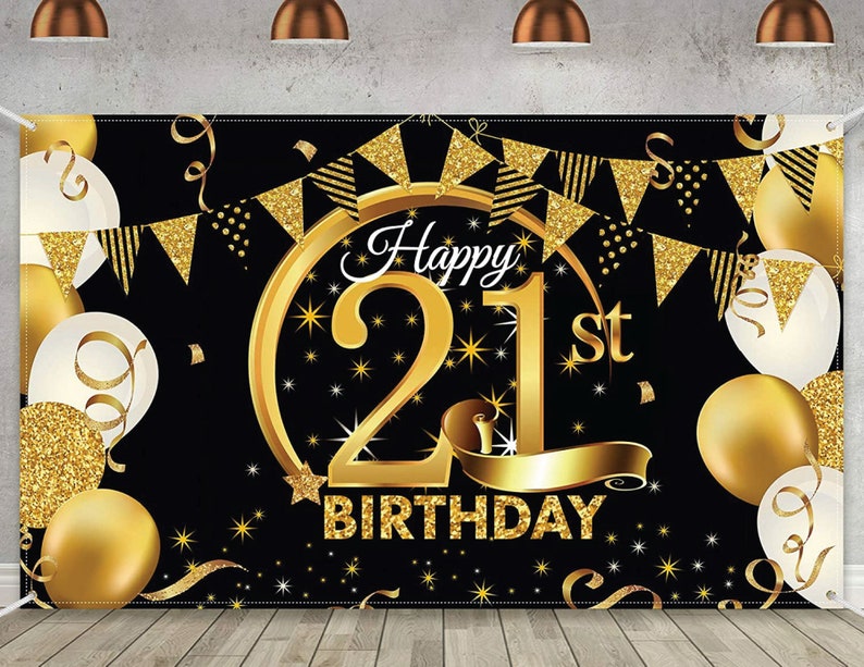 May include: Black and gold happy 21st birthday banner with gold confetti and white balloons. The banner has a large gold number 21 with stars and a gold ribbon.