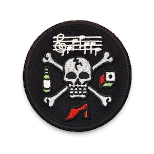 May include: Round black patch with a skull and crossbones design. The skull has a lightning bolt on its head, with musical notes above. A bottle, high heel, and dice are also featured.