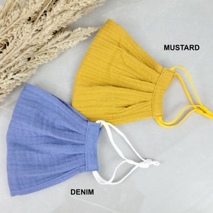May include: Two fabric face masks, one mustard yellow and one denim blue, with adjustable elastic ear loops. The masks are made of a soft, breathable material.