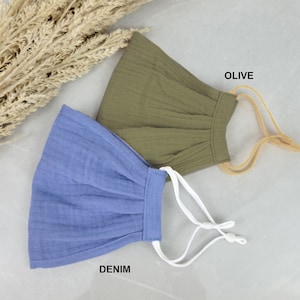 May include: Two face masks, one in denim blue and one in olive green, with elastic ear loops. The text "DENIM" and "OLIVE" is printed below each mask.