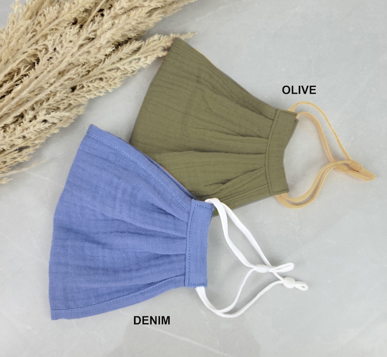 May include: Two face masks, one in denim blue and one in olive green, with elastic ear loops. The text "DENIM" and "OLIVE" is printed below each mask.