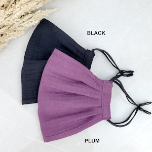 May include: Two face masks, one black and one plum, with adjustable ear loops.  BLACK and PLUM text is visible below the masks.