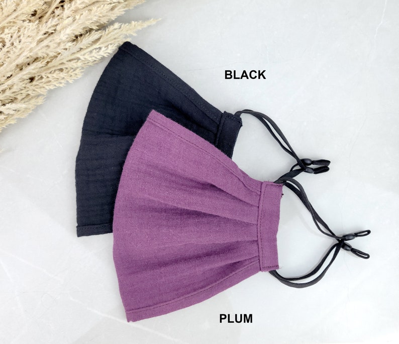 May include: Two face masks, one black and one plum, with adjustable ear loops.  BLACK and PLUM text is visible below the masks.