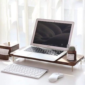 May include: A wooden laptop stand with a laptop, keyboard, mouse, and a small potted cactus on top. The stand has brass legs and a power strip.