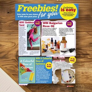 May include: A promotional flyer titled Freebies! for you featuring multiple giveaway sections including Goddess Tarot, Bulgarian Rose Oil, A Colourful Dose of Optimism, and Chakra crystal sets, with text details and product imagery on a wood grain background.