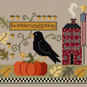 May include: Cross-stitch design featuring a black crow perched on an orange pumpkin. The design includes a red house, an American flag, and the text "Be Grateful Not Greedy". Acorns and fall leaves complete the autumn theme.