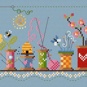 Può includere: Uno schema di punto croce che presenta una fila di colorati porta-spilli con vari abbellimenti, tra cui un alveare, un gomitolo di lana e un fiore in fiore. I porta-spilli sono decorati con cuori, pois e strisce. Ci sono anche api e farfalle che volano intorno ai porta-spilli.