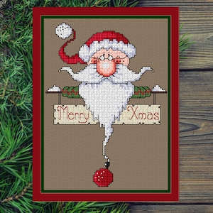 Può includere: Biglietto di Natale a punto croce con Babbo Natale con barba bianca, cappello rosso e occhiali. Il biglietto ha un bordo rosso e le parole "Merry Xmas" su un cartello. Una palla rossa è appesa sotto.