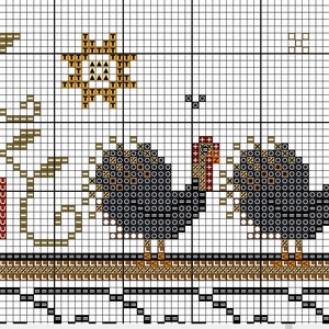 May include: Cross stitch pattern featuring two turkeys, pumpkins, and a sun. The turkeys are black and white with red heads. The pumpkins are orange and brown. The sun is yellow and brown.