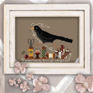 May include: A black bird with a needle and thread in its beak sits on a branch above a collection of sewing supplies, including spools of thread, scissors, buttons, and a thimble. The image is framed in white and has the text "I spread beauty through colourful art" at the bottom.