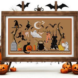 May include: A cross-stitch pattern depicting a Halloween scene with a black cat, a ghost, and witches hanging laundry on a clothesline. The text "Rest in Peace" is on a tombstone.
