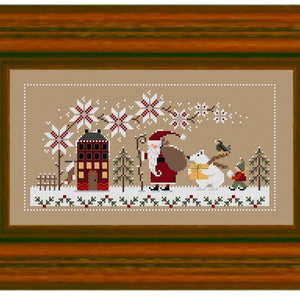 May include: Cross-stitch artwork in a wooden frame depicts a winter scene. Santa Claus, a polar bear, and a child walk through the snow. A house and snowflakes are also featured. The color palette includes red, brown, white, and green.