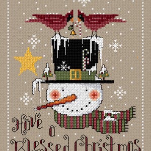 Può includere: Design a punto croce con un pupazzo di neve con cappello a cilindro nero, sciarpa a righe e naso a carota arancione. Due cardinali rossi sono appollaiati sul cappello. Il testo recita "Have a Blessed Christmas."