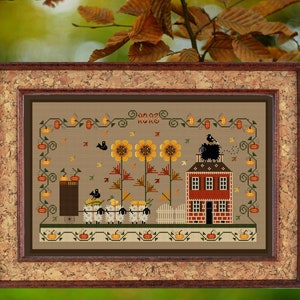Può includere: Schema di ricamo a punto croce con una casa in mattoni rossi con tetto nero, tre girasoli, un gregge di pecore e zucche. Lo schema è incorniciato in una cornice di legno marrone con retro in sughero. Il testo "Home Sweet Home" è ricamato sopra la casa.