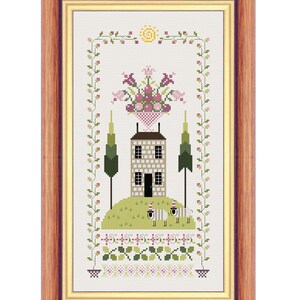 Puede incluir: Un patrón de punto de cruz que presenta una casa con una cesta de flores encima, dos árboles y dos ovejas en un campo. La casa es marrón y blanca, los árboles son verdes y las ovejas son blancas con detalles negros. El campo es verde y tiene un borde de flores y hojas.
