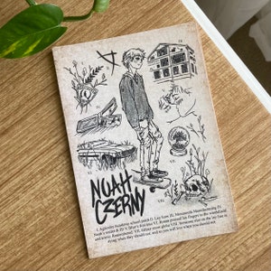 K&ouml;nnte beinhalten: Eine Schwarzwei&szlig;illustration eines jungen Menschen, das auf einem Skateboard steht. Die Illustration ist von verschiedenen Symbolen und Objekten umgeben, darunter ein Geb&auml;ude, ein Auto, eine Schneekugel, ein Sch&auml;del und ein Herz. Der Text "NOAH CZERNY" ist in gro&szlig;en Buchstaben am unteren Rand der Illustration geschrieben. Der Text unter der Illustration lautet: "L. Aglionby Academy school patch II. Ley lines III. Monmouth Manufacturing IV. Noah's wallet & ID V. Blue's first kiss VI. Ronan pressed his fingers to the windshield and wrote: Remembered VII. Glitter snow globe VIII. Someone else on the ley line is dying when they should not, and so you will live when you should not."