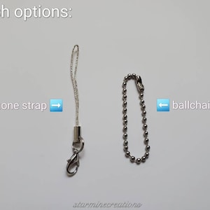 May include: Image showing two finish options: a silver phone strap with a lobster clasp and a silver ball chain. Text indicates the options are "phone strap" and "ballchain". The text "finish options:" is at the top.