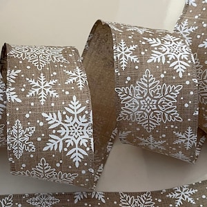 May include: A roll of brown burlap ribbon with a white snowflake pattern. The ribbon is perfect for adding a touch of rustic elegance to your holiday decor.