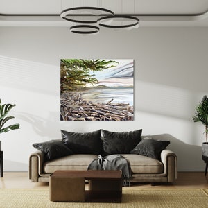 May include: A square canvas art print depicting a coastal scene with driftwood, a sandy beach, and a cloudy sky. The artwork features a color palette of greens, blues, and browns, and is displayed in a modern living room setting.