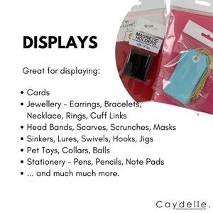 May include: A set of magnetic holders for displaying cards, jewelry, headbands, and other small items. The holders are black and come in a clear plastic package. The text on the package reads "Magnetic Holders for Makers, Planners & Tags".