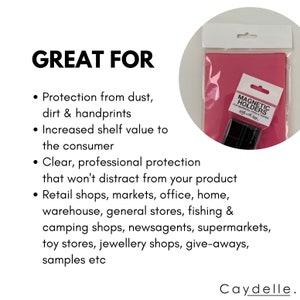 May include: Pink packaging with a clear plastic window showing black magnetic holders for markers, pens, and textas. The text "MAGNETIC HOLDERS" is printed on the packaging. The text "GREAT FOR" is printed in black on a white background. The text below "GREAT FOR" lists several uses for the magnetic holders, including retail shops, markets, office, home, warehouse, general stores, fishing and camping shops, newsagents, supermarkets, toy stores, jewellery shops, give-aways, and samples.
