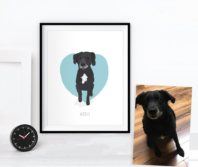 May include: A framed art print featuring a black dog with a white chest marking, set against a light blue heart shape. The dog's name, "Addie," is written below. A small, black analog clock is on the left.