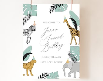 May include: A white welcome sign with a jungle theme. It says "Welcome to James' Second Birthday" with a zebra, giraffe, leopard, and elephant wearing party hats. The text also says "June 17th, 20XX Have a Wild Time!"