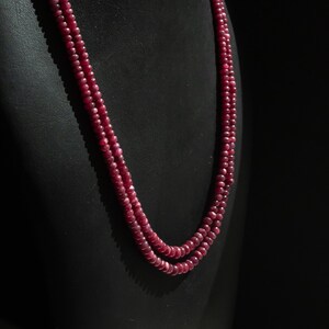 Può includere: Una collana a doppio filo realizzata con perline di rubino rosso scuro su un espositore in velluto nero.