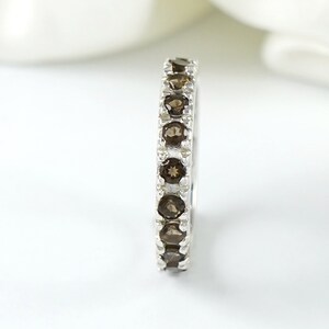 May include: A silver band ring with a row of brown gemstones.