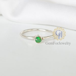 May include: A silver ring with a green opal gemstone. The ring is simple and elegant, perfect for everyday wear.