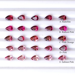 May include: A close-up view of 20 pear-shaped gemstones arranged in five rows of four. The gemstones are various shades of pink, from a deep red to a light salmon color. The gemstones are labeled with their color names: Rubellite, Radiant Pink, Pink Orange, Pink, and Salmon Pink.