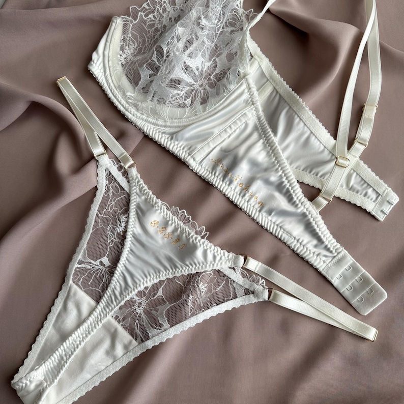 Peut inclure: Ensemble de lingerie en dentelle blanche avec des motifs floraux d&eacute;licats. Le soutien-gorge a des bretelles r&eacute;glables et une finition satin&eacute;e. La culotte assortie a une d&eacute;licate bordure en dentelle et un n&oelig;ud en satin.