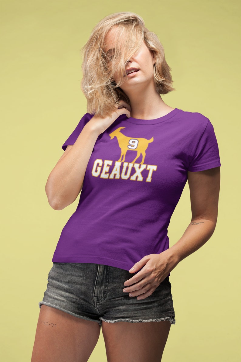 May include: Purple t-shirt with a gold silhouette of a goat with the number 9 on it and the text "GEAUX'T" underneath.
