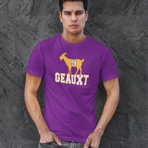 May include: A purple t-shirt with a yellow silhouette of a goat with the number 9 on its side and the word "GEAUXT" printed below.